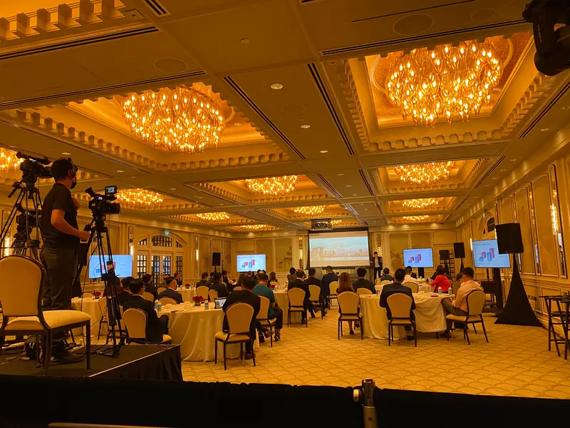 Camera operators at the back of a chandelier ballroom during an event