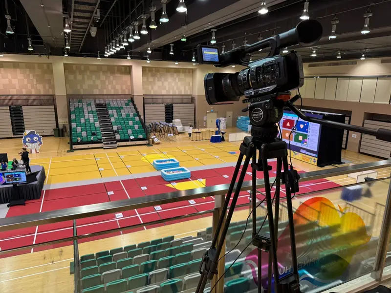 Camera on a tripod in the gallery above a sports hall event