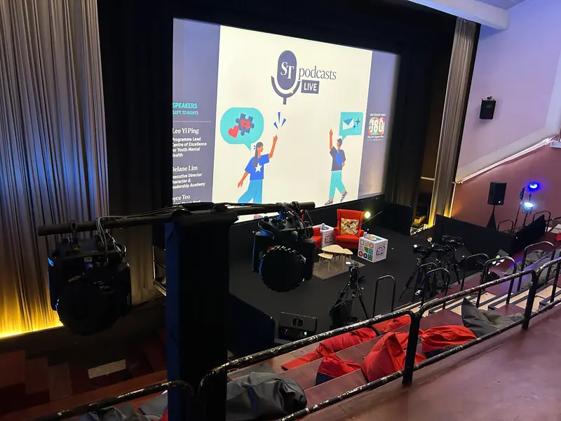 Cinema set up for a live show, with cameras and speakers below the screen