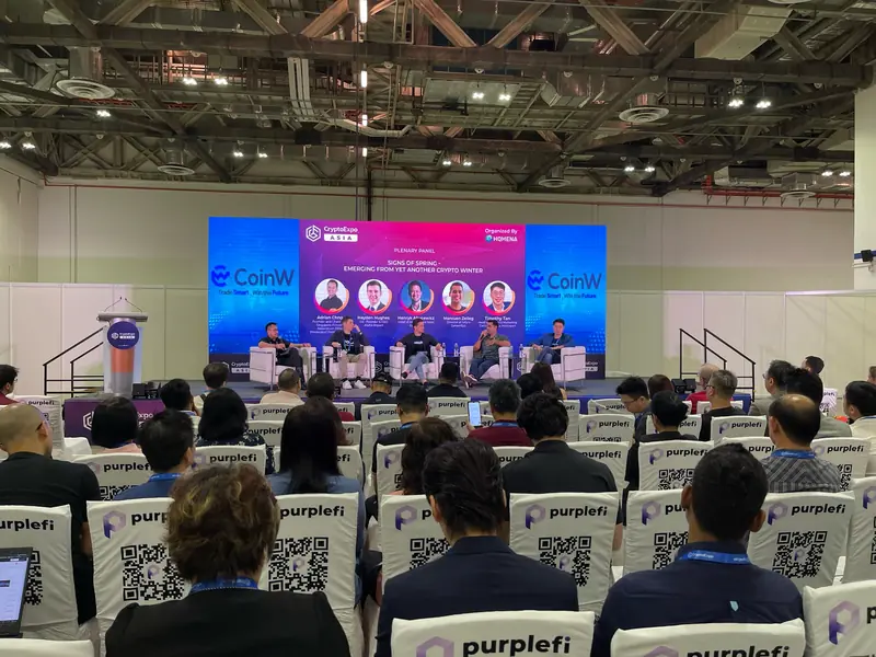 Panel discussion on an exhibition hall stage with an LED backdrop