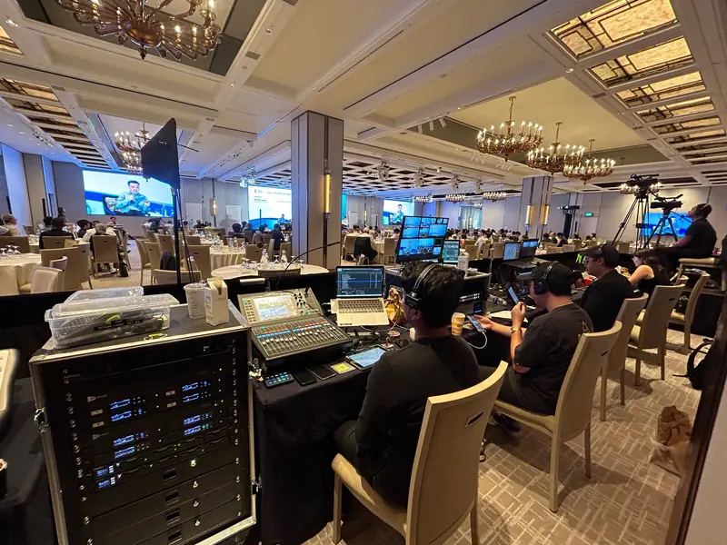 Sound rack and mixer at a ballroom conference, cameras behind