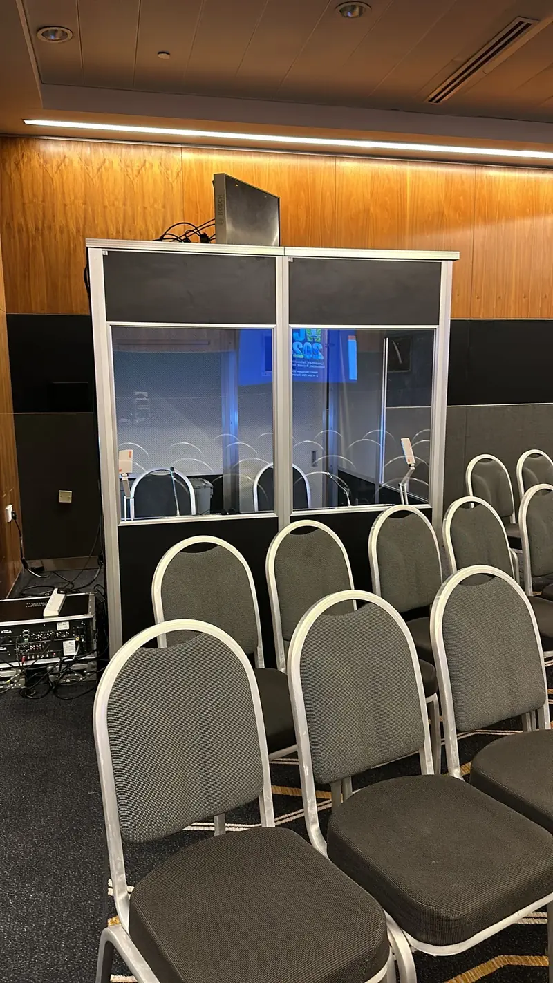 Simultaneous translation booth set up behind rows of chairs