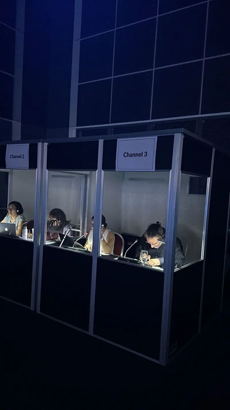 Simultaneous translation booths with interpreters at work