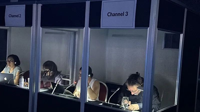 Two interpretation booths labelled Channel 2 and Channel 3, with interpreters working in headsets