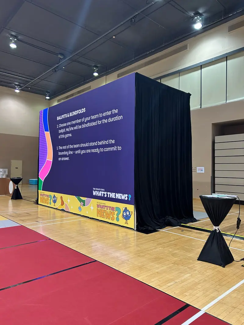 LED wall framed with black drapes on a sports hall floor